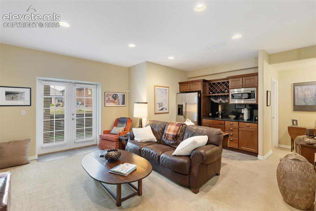 Image 21 of 28: Living area featuring recessed lighting, a built-in wet bar with wood cabin