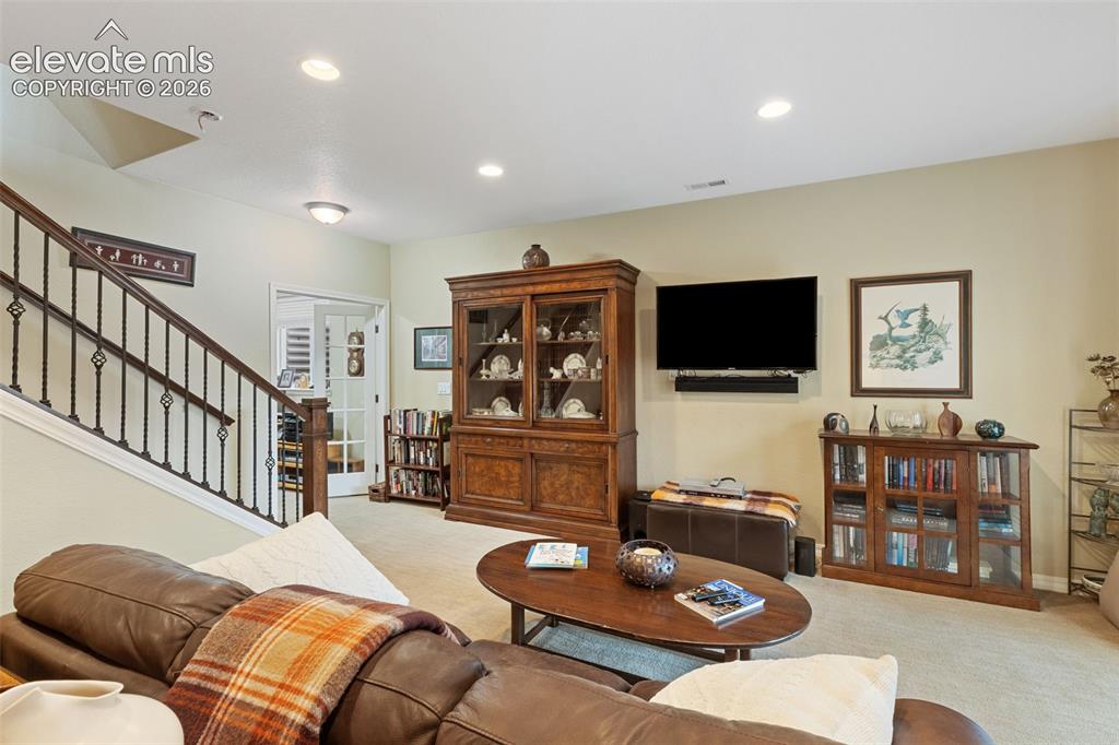 Image 22 of 28: Open living area featuring recessed lighting and wall-to-wall carpeting.