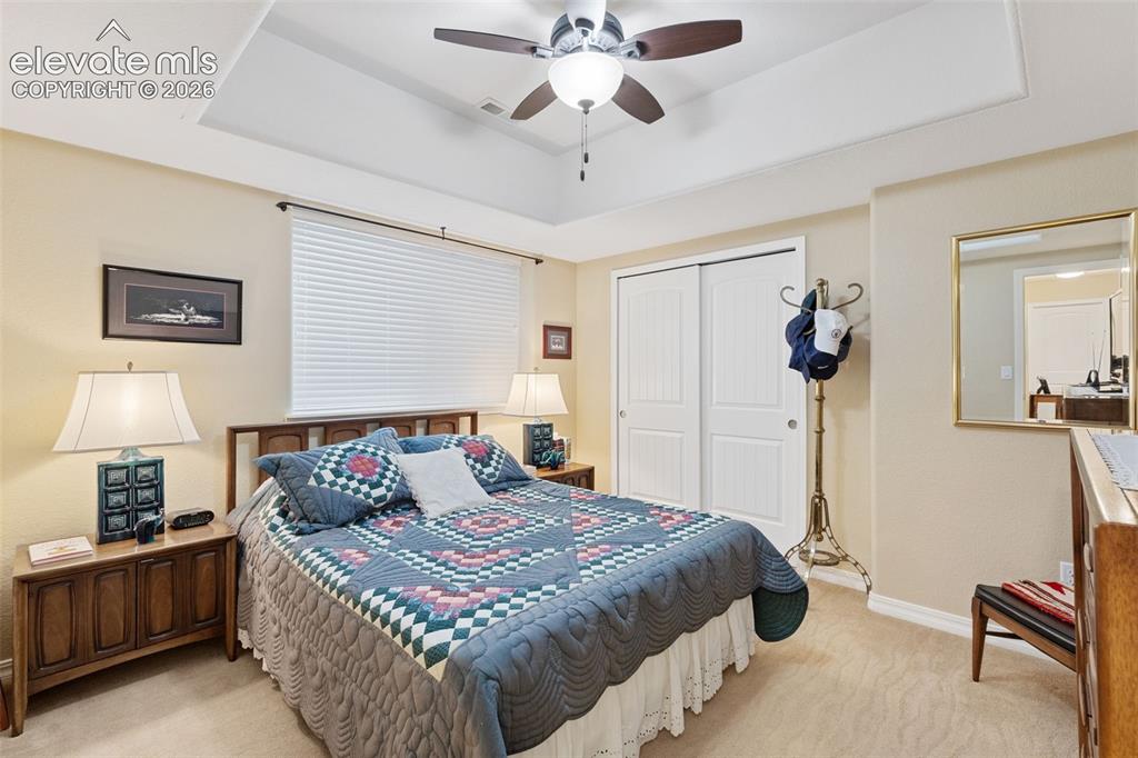 Image 24 of 28: Carpeted bedroom with a ceiling fan, recessed lighting, and an entryway to