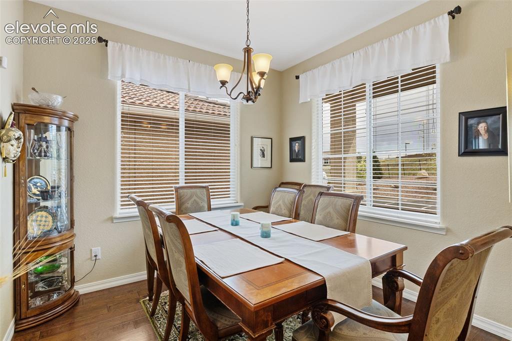 Image 4 of 28: Formal dining area featuring wood-finish flooring.