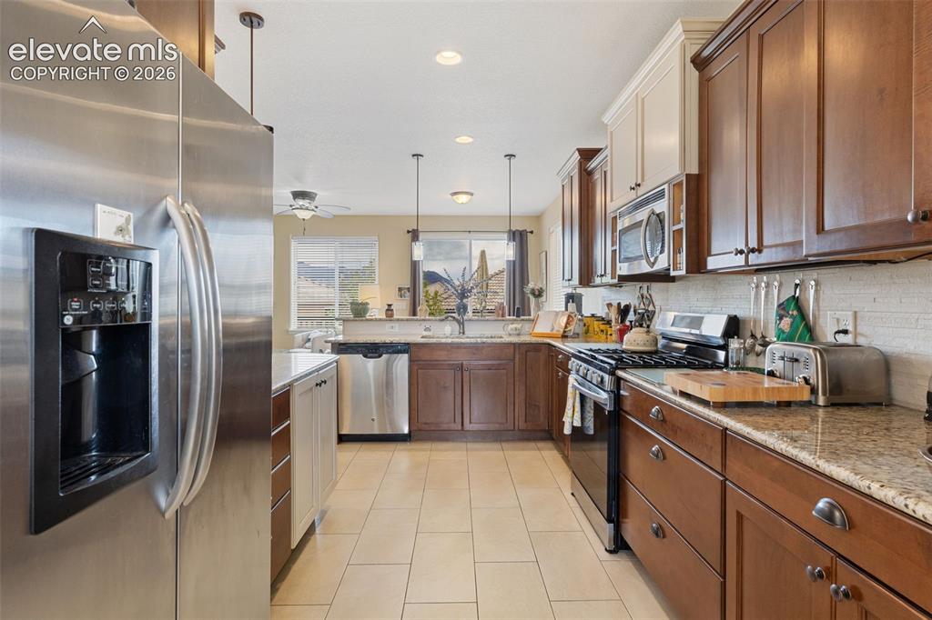 Image 6 of 28: Kitchen featuring stainless steel appliances, granite countertops, tile flo
