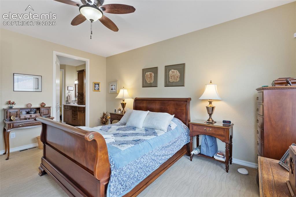 Image 9 of 28: Carpeted master bedroom with a ceiling fan, recessed lighting, and an entry