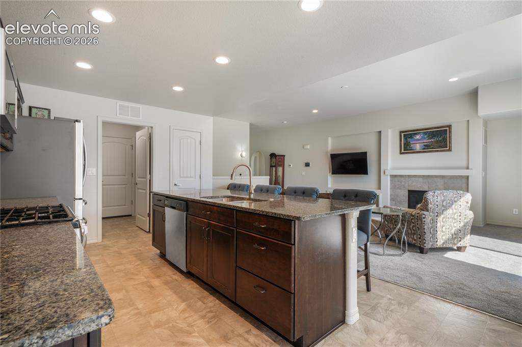 Image 12 of 50: Kitchen with large island, granite countertops, gas range, abundant cabinet