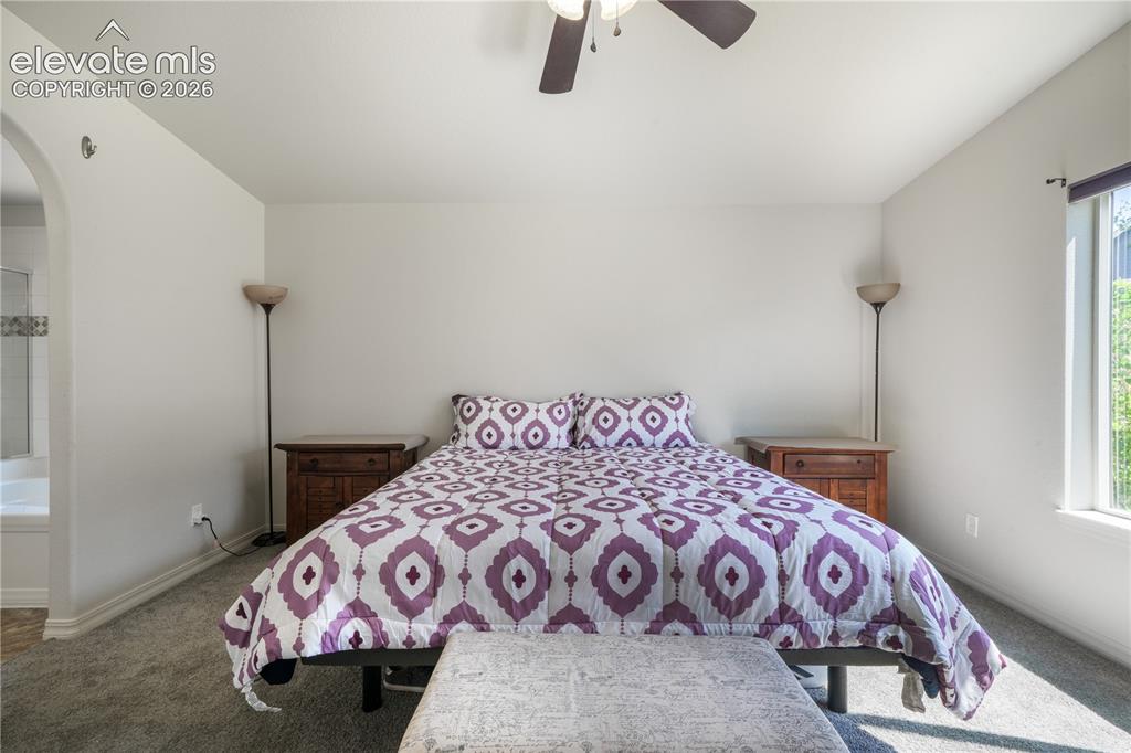 Image 17 of 50: Main level primary bedroom with ensuite 5 piece bathroom with granite count