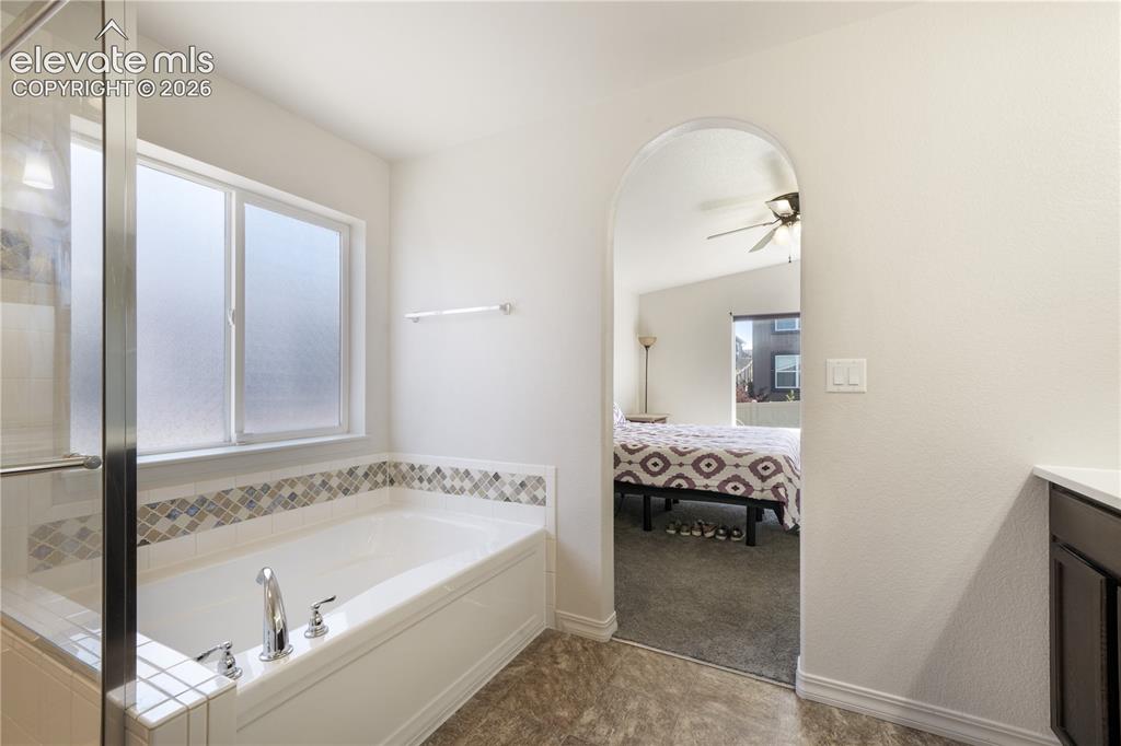 Image 22 of 50: Main level primary 5 piece bathroom with dual sinks, granite counters, free