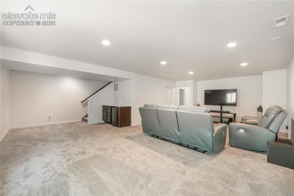Image 28 of 50: Basement family room with mini wet bar, new carpet