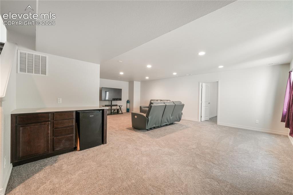 Image 29 of 50: Basement family room with mini wet bar, new carpet