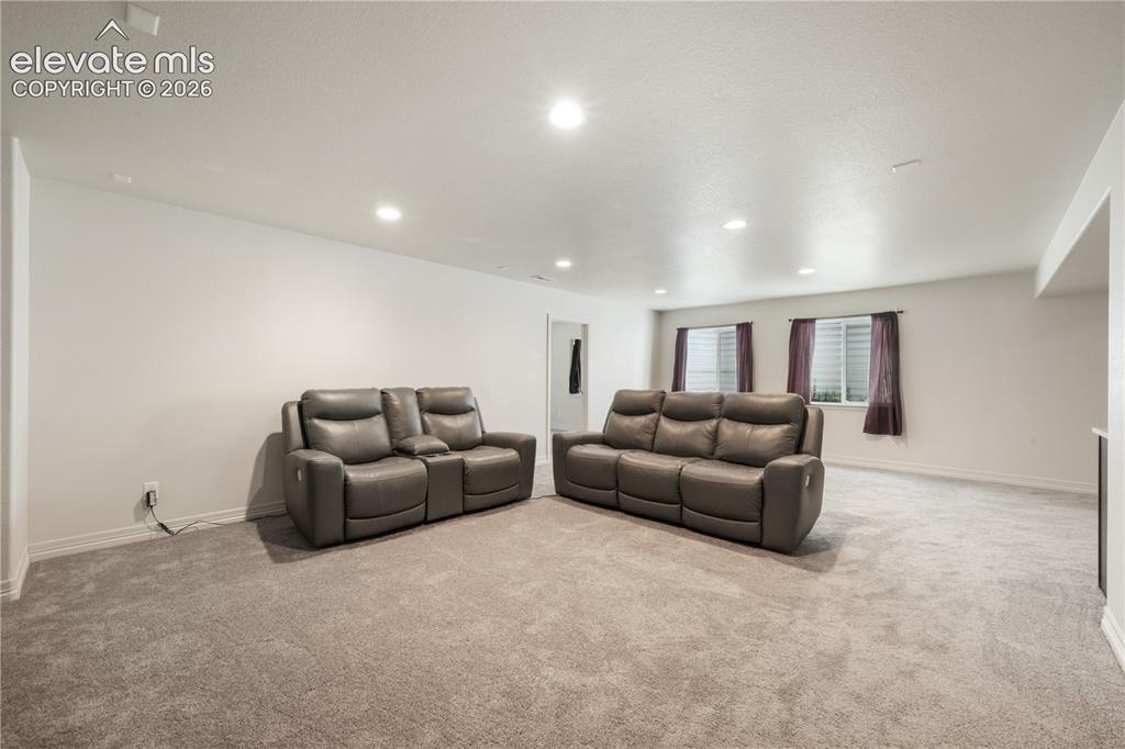 Image 30 of 50: Basement family room with mini wet bar, new carpet