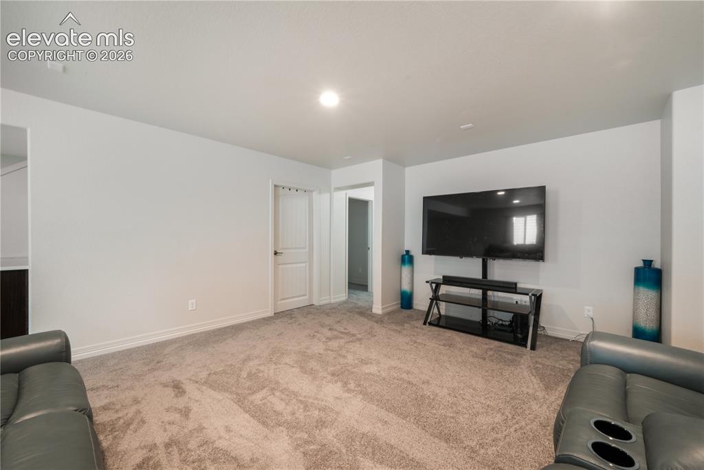 Image 33 of 50: Basement family room with mini wet bar, new carpet