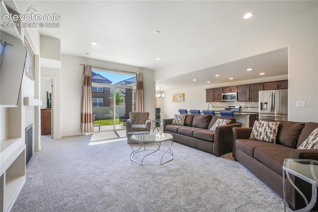 Image 7 of 50: Livingroom with open concept, gas fireplace, large patio sliding doors and