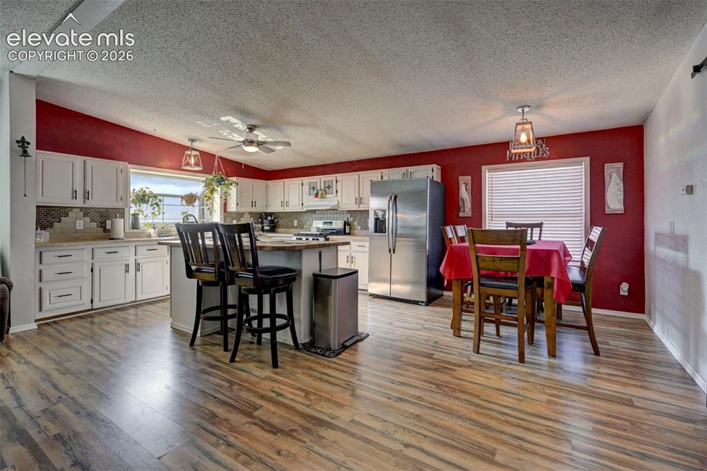 Image 10 of 31: Kitchen with white cabinets, stainless steel appliances, a textured ceiling