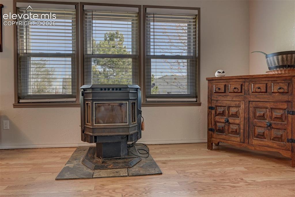 Image 8 of 31: Detailed view of a wood stove, wood finished floors, and a textured wall