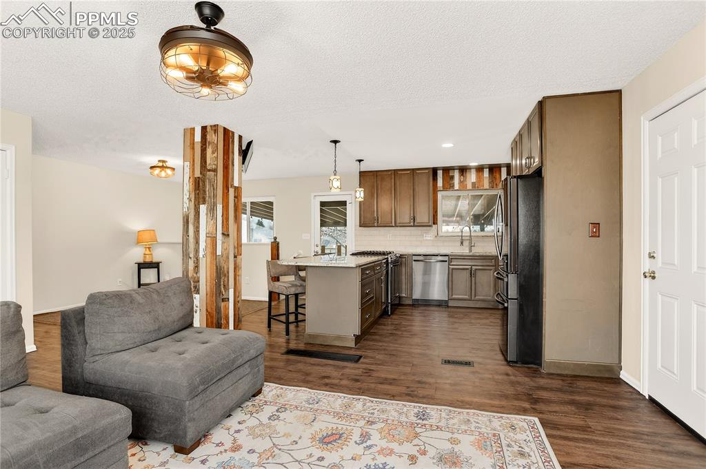 Image 12 of 42: Living room is adjacent to kitchen