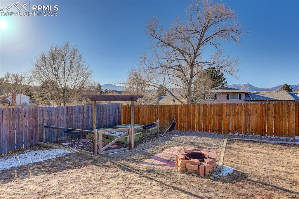Image 38 of 42: Backyard designated garden area and fire pit
