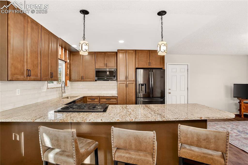 Image 5 of 42: Kitchen breakfast bar accented with pendalent lighting