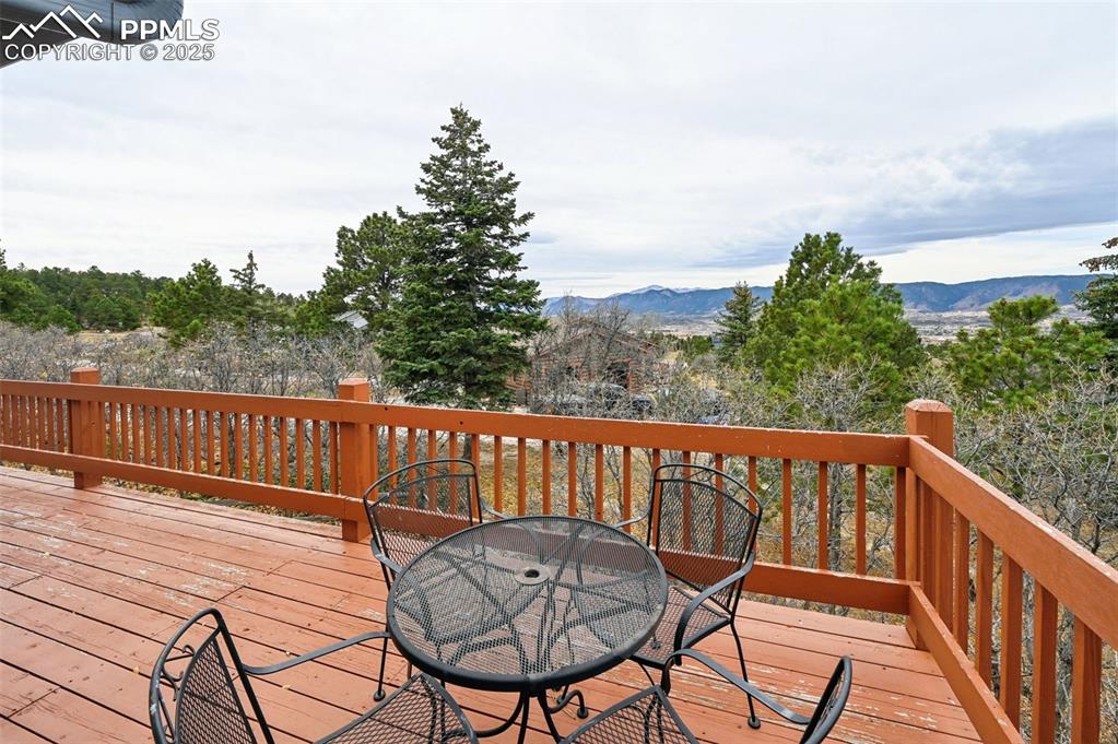 Image 10 of 49: Deck with a mountain view and outdoor dining area