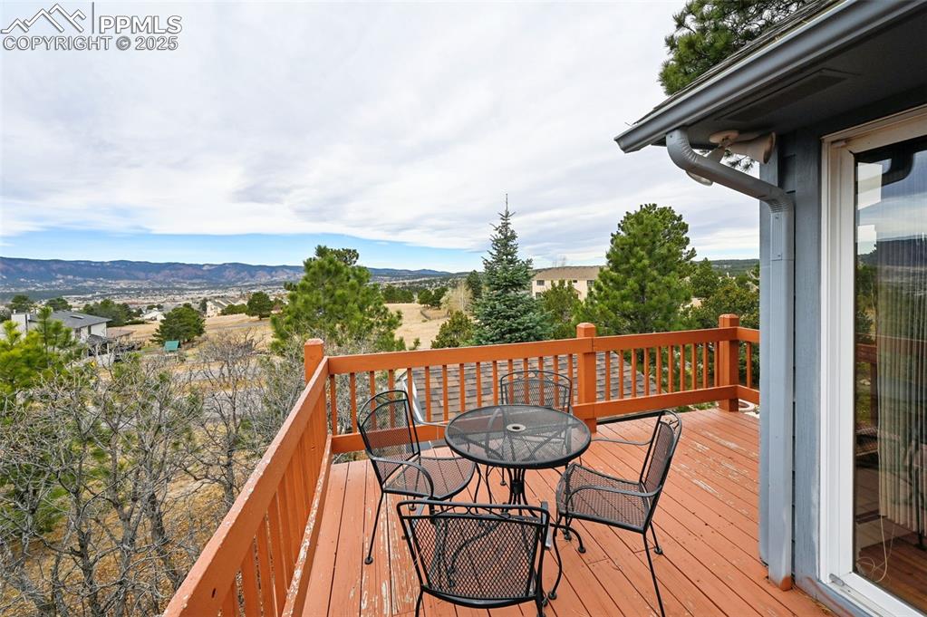 Image 11 of 49: Wooden terrace with outdoor dining area and a mountain view