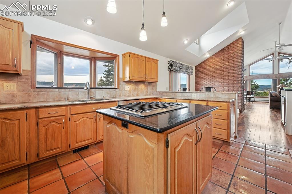Image 25 of 49: Kitchen with dark stone counters, plenty of natural light, tasteful backspl