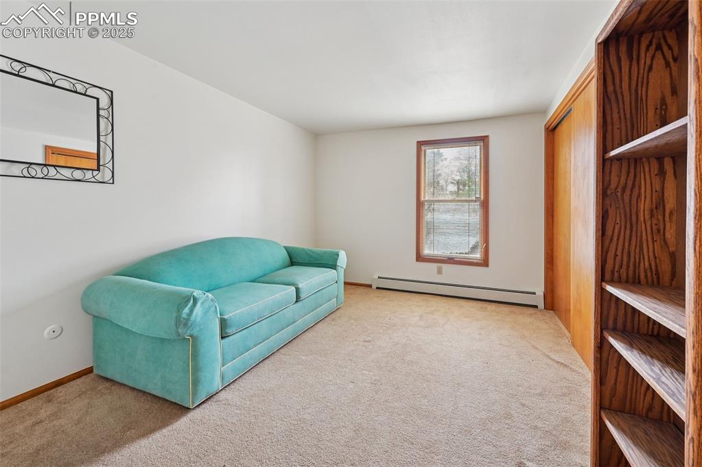 Image 41 of 49: Living area featuring carpet floors and a baseboard radiator