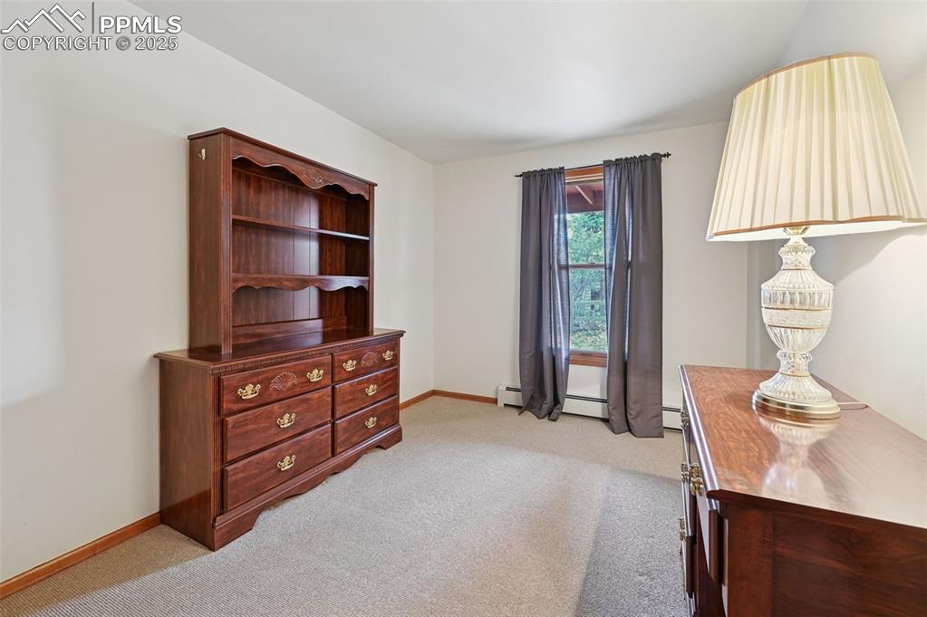 Image 43 of 49: Living area featuring light colored carpet and baseboard heating