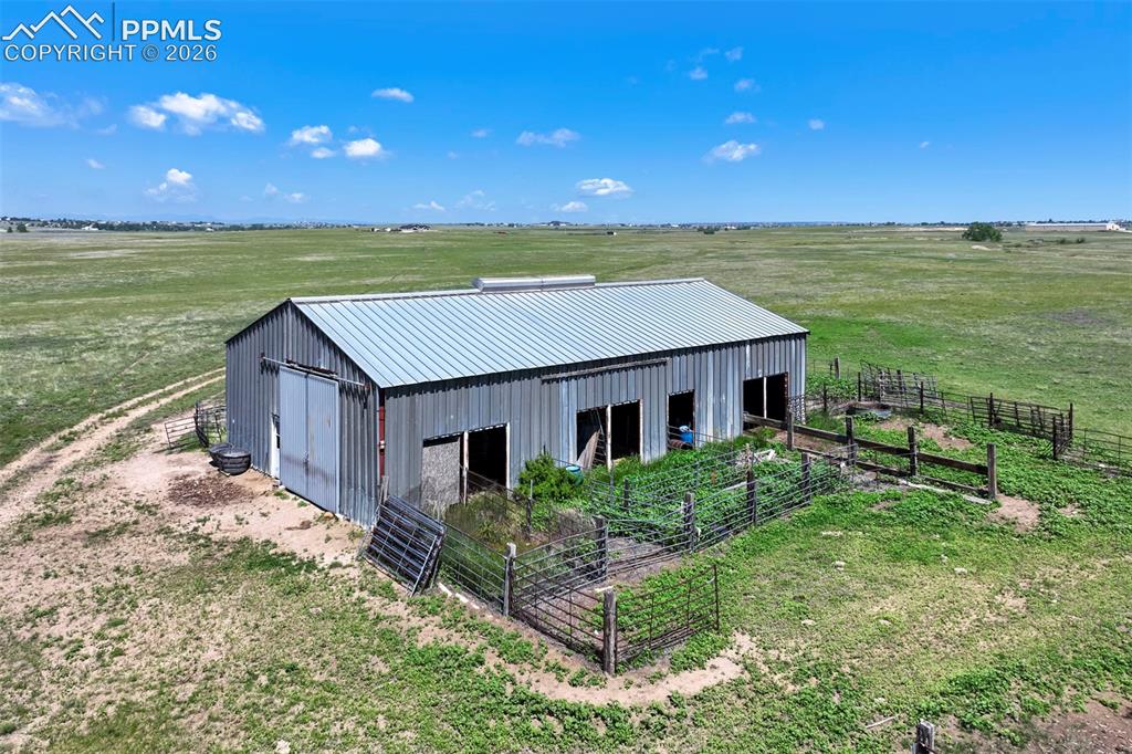 Image 11 of 50: Agricultural outbuilding featuring a corrugated metal roof and siding, mult