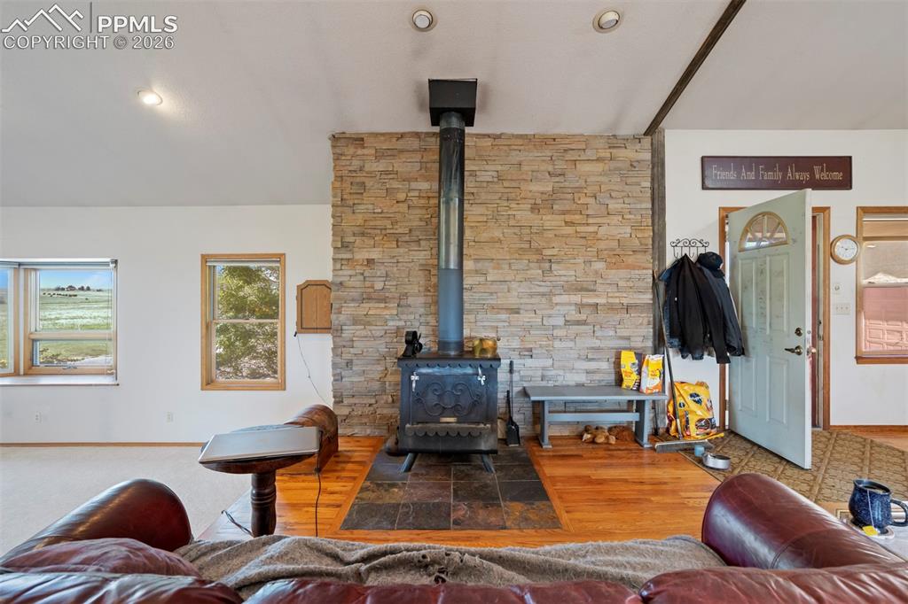 Image 14 of 50: Central wood-burning stove featuring a stone surround and a slate hearth