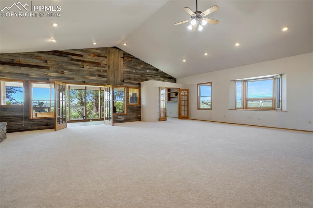 Image 19 of 50: Expansive room featuring a vaulted ceiling with recessed lighting and a cei