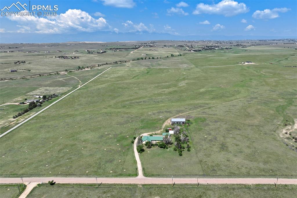 Image 2 of 50: Expansive rural property featuring a main residence with a green roof, a la
