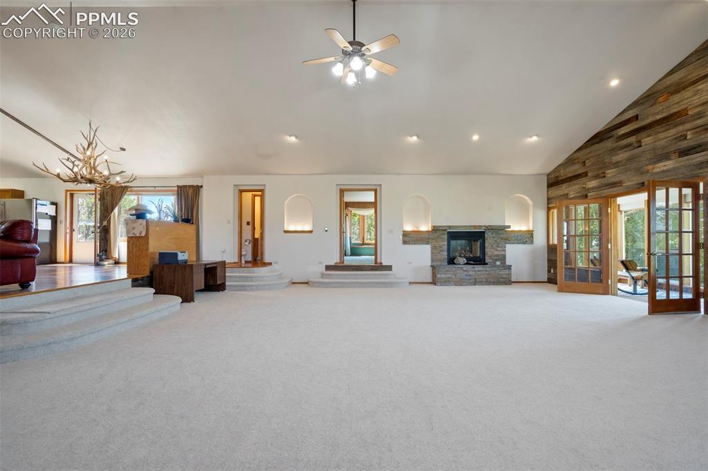 Image 20 of 50: Spacious interior featuring a stone fireplace with arched niches, wood-fini