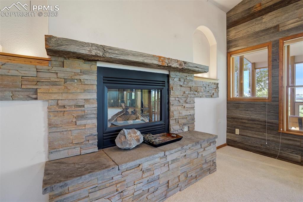 Image 21 of 50: Stone-clad fireplace with a substantial timber mantel