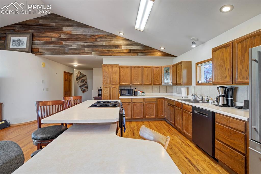 Image 27 of 50: Spacious kitchen featuring wood-finish flooring, a large island with an int