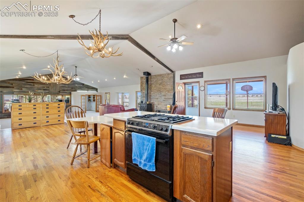 Image 28 of 50: Open-concept kitchen featuring a center island with integrated range, white