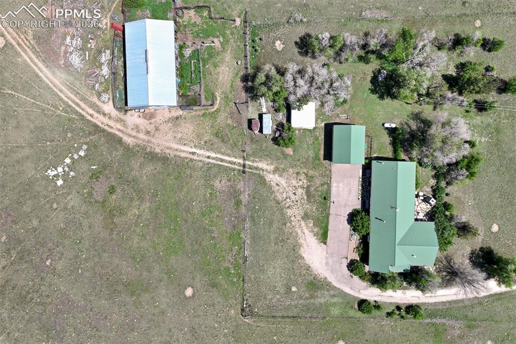 Image 3 of 50: Expansive aerial view of a property featuring multiple structures and open