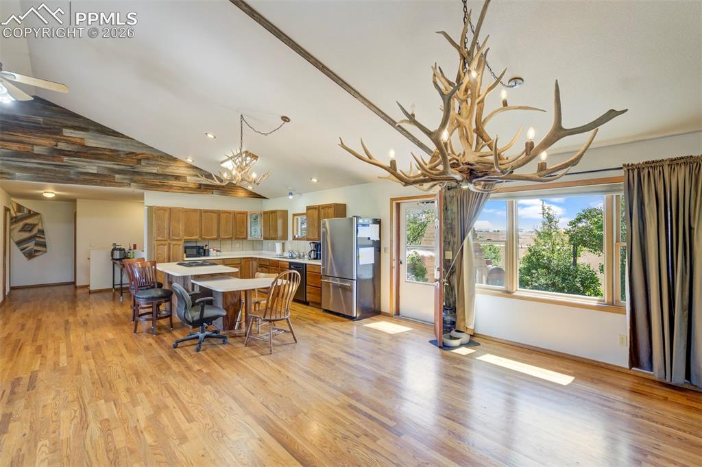 Image 32 of 50: Spacious open-concept living area featuring wood-finish flooring, a vaulted