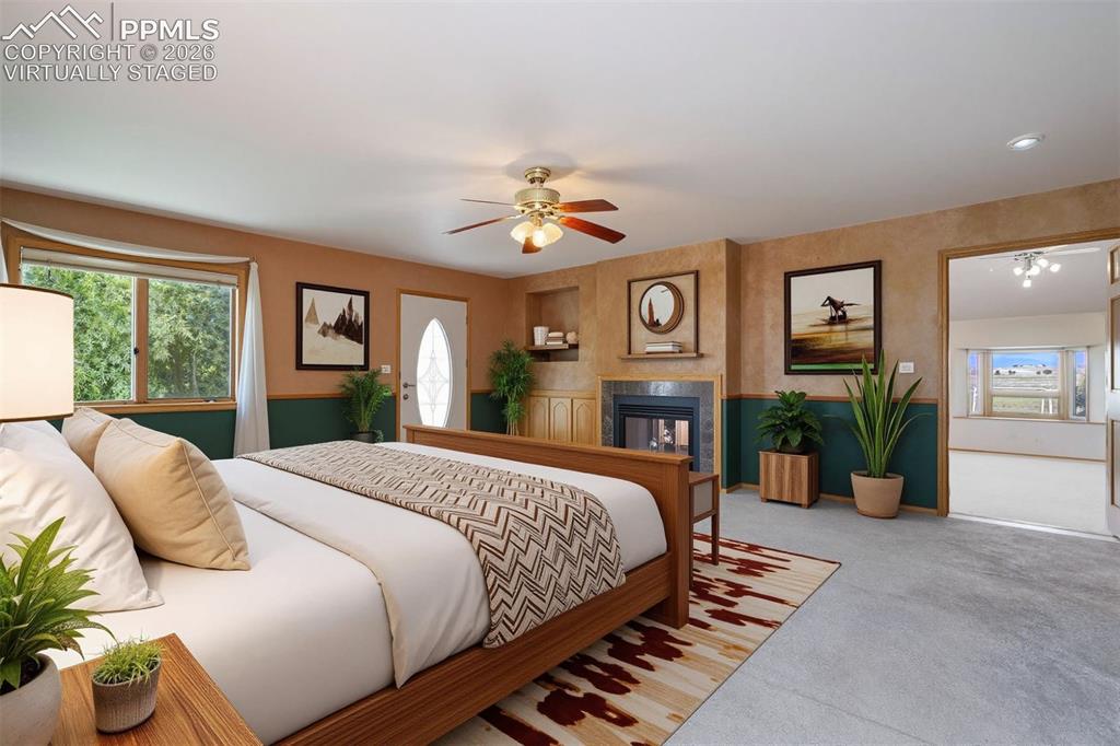 Image 33 of 50: virtually staged Carpeted room featuring a built-in fireplace with a tiled