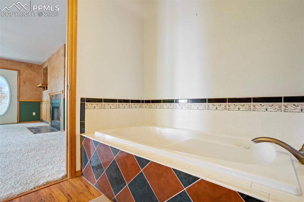 Image 37 of 50: Built-in soaking tub featuring patterned tile surround