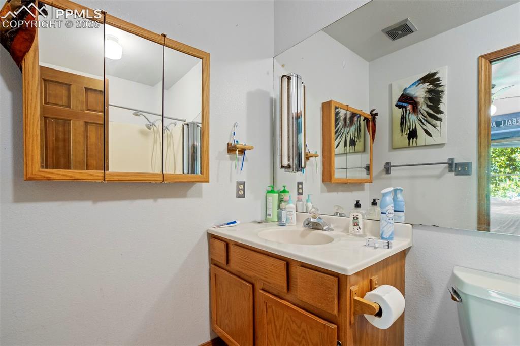 Image 42 of 50: Bathroom vanity with a white countertop and integrated sink, framed by a la