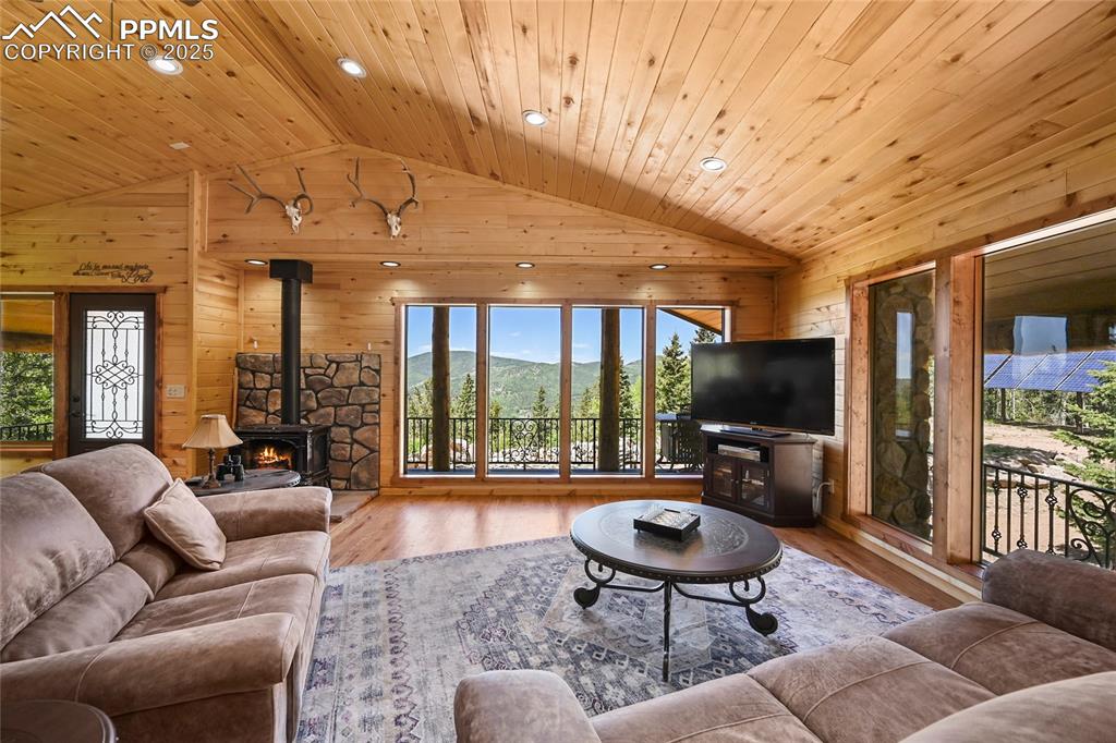 Image 11 of 50: Living area featuring lofted ceiling, wood finished floors, wooden ceiling,