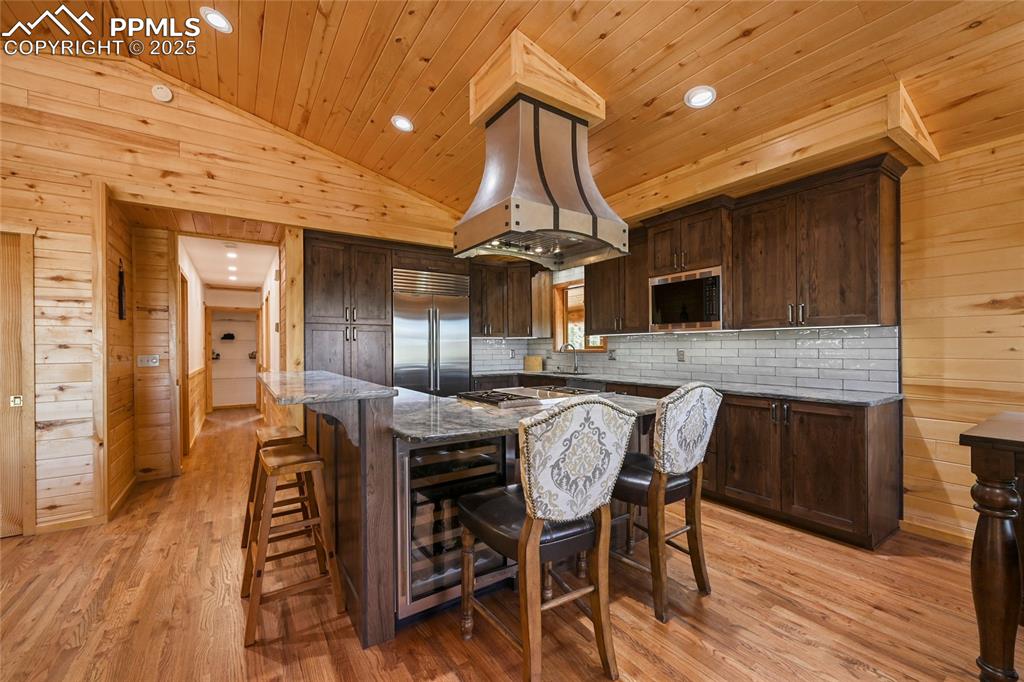 Image 15 of 50: Kitchen with vaulted ceiling, wooden ceiling, built in appliances, wooden w