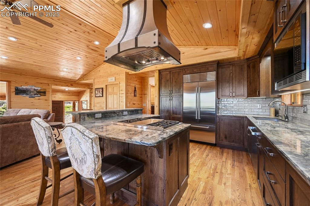 Image 18 of 50: Kitchen featuring extractor fan, a sink, built in appliances, and wood ceil