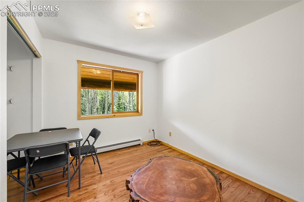 Image 29 of 50: Office space with baseboards, a baseboard heating unit, and light wood-styl