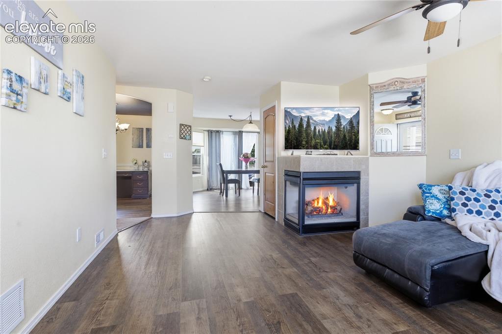 Image 4 of 31: STEP INSIDE TO A SPACIOUS MAIN-LEVEL LIVING ROOM FEATURING A TWO-SIDED FIRE