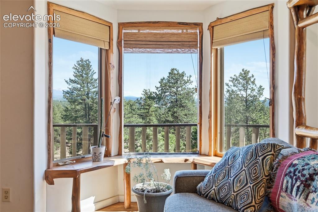 Image 11 of 49: View from living room through gable windows. Sitting ledge at the bottom of