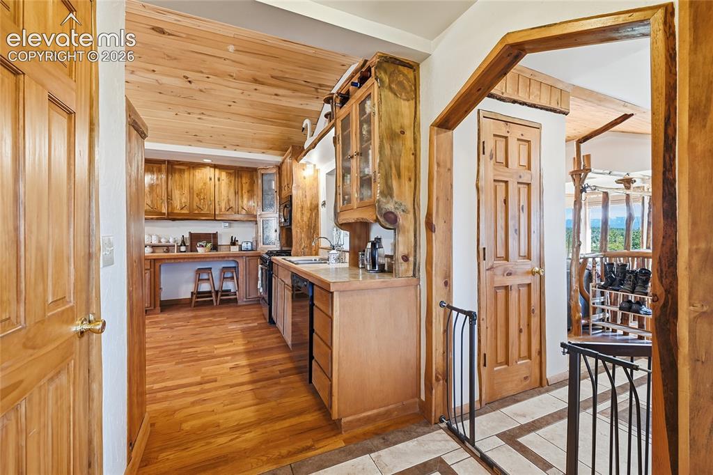 Image 14 of 49: View from dining room looking into the kitchen. Notice the custom woodworki
