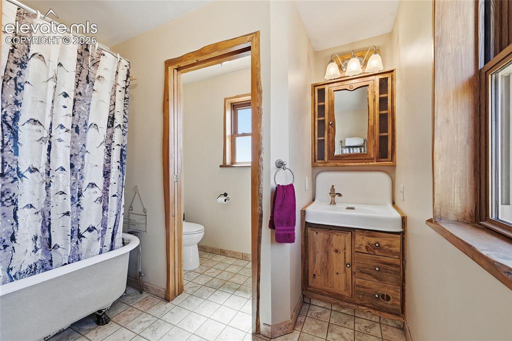 Image 27 of 49: Upstairs guest bathroom with soaking tub.