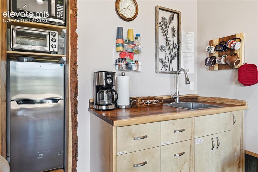Image 29 of 49: Kitchenette area, all appliances remain after the purchase.