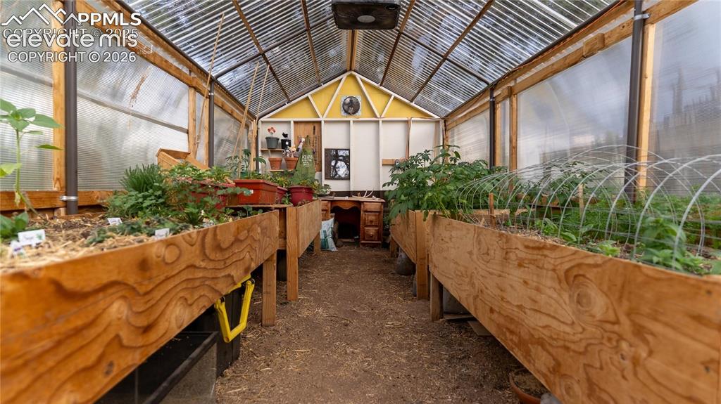 Image 40 of 49: Greenhouse. Four large planting beds for gardeners. Rain capture system p