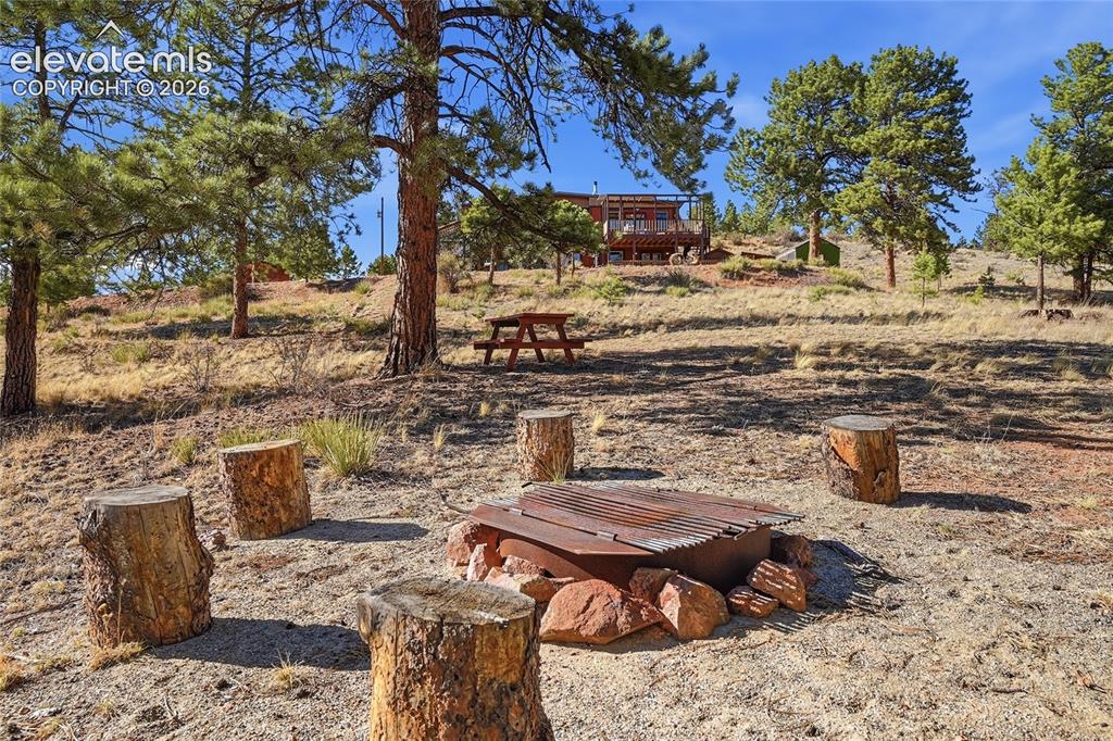 Image 42 of 49: Firepit area for family gatherings. Surrounding ground area is clear of ve