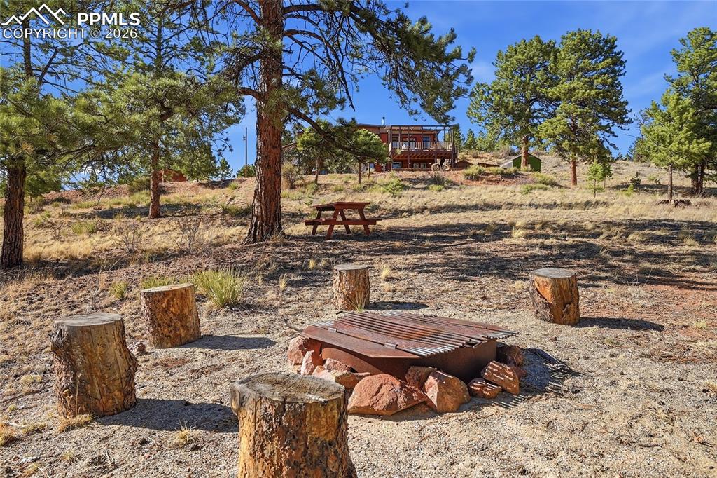 Image 43 of 50: Firepit area for family gatherings.  Surrounding ground area is clear of ve