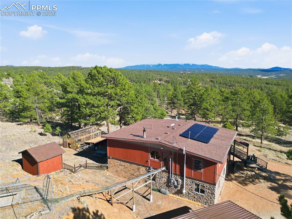 Image 46 of 49: Aerial view of the house and surrounding area. Solar panels are paid for a